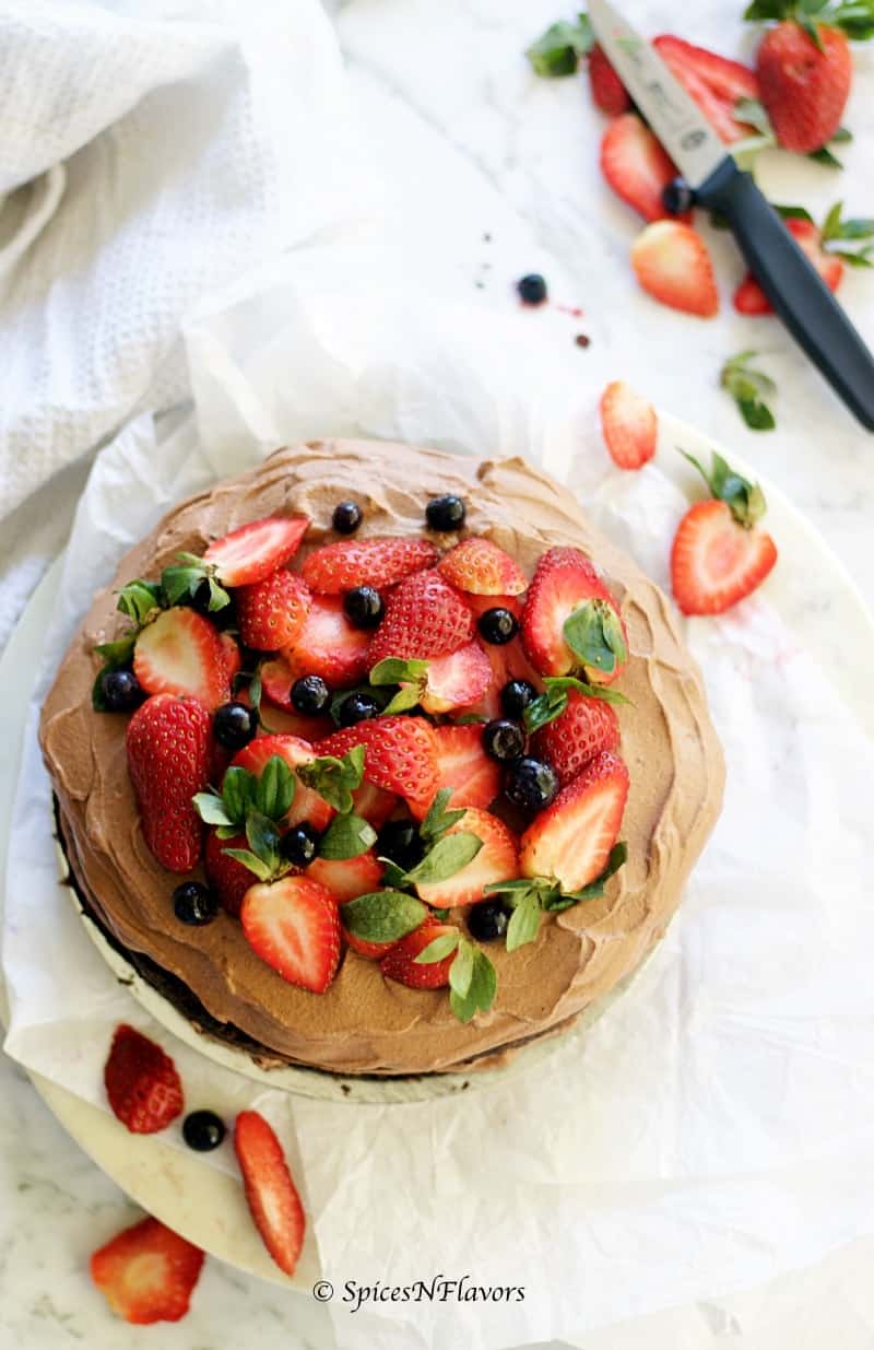 overhead view of one bowl chocolate cake with strawberries and blueberries
