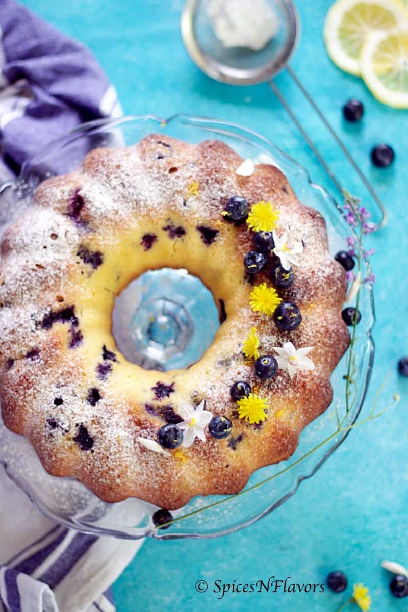 vertical image of blueberry lemon pound cake showing the entire baked cake