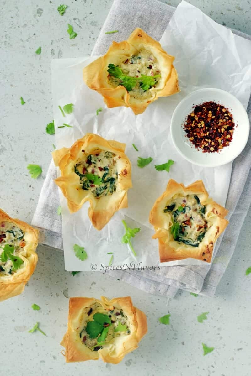 overhead view of spinach and feta filo cups or spanokopita showing the filling inside.