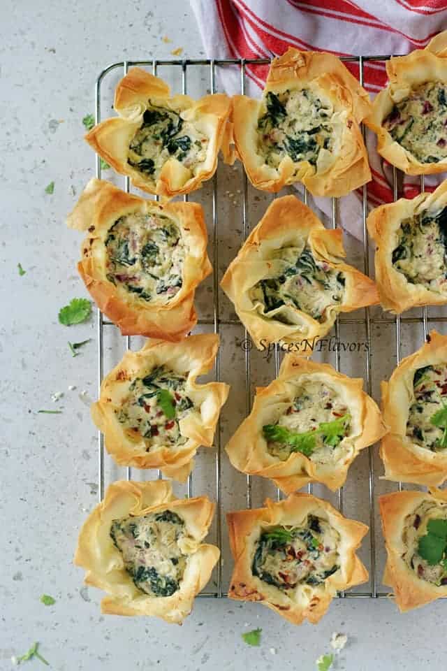 top view of spanokopita or spinach and feta filo cups placed on a cooling rack