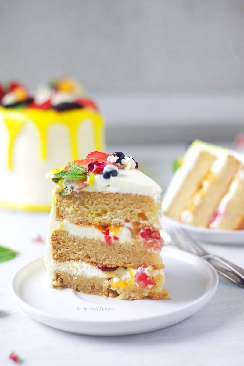 cut slice of Fresh Fruit Cake showing the inner texture of the cake with whipped cream and fruits
