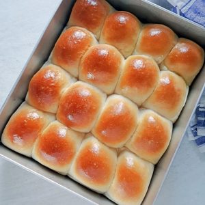 ladi pav bread placed in the baking tray with a tea towel adjacent to it