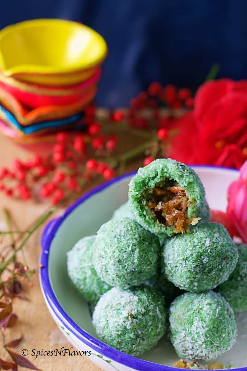 half portion of the laddu showing the texture and the filling inside placed on top of few other ladoos