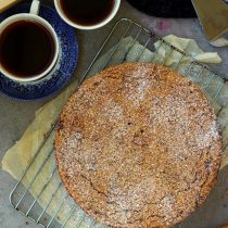 overhead image of apple crumb cake with black tea and books