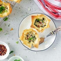 two pieces of spinach and feta filo cups or spanokopita served on a plate