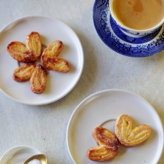 palmier cookies served on a white plate along with evening cup of tea