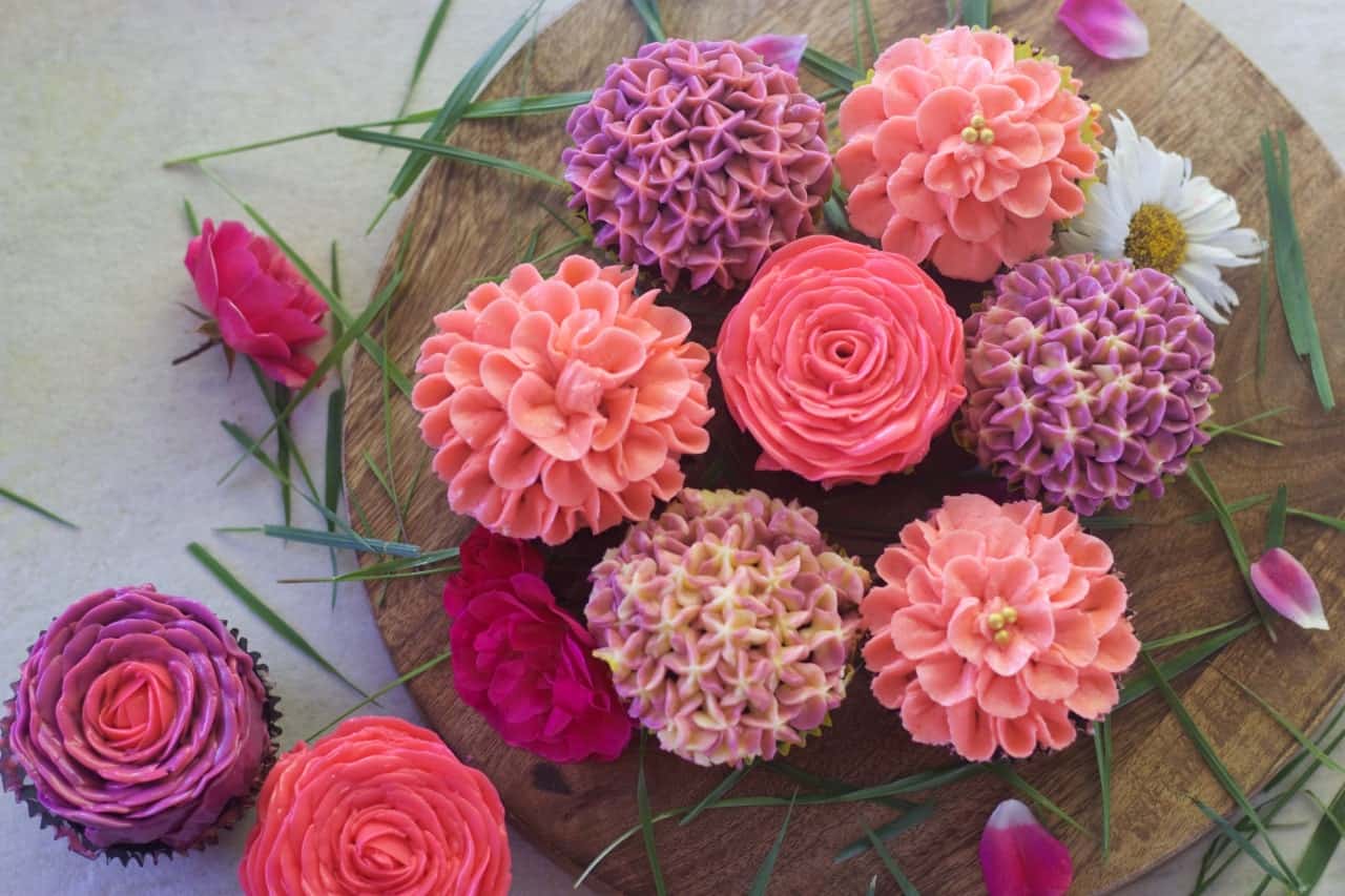 overhead view of buttercream flowers arranged on a wooden board