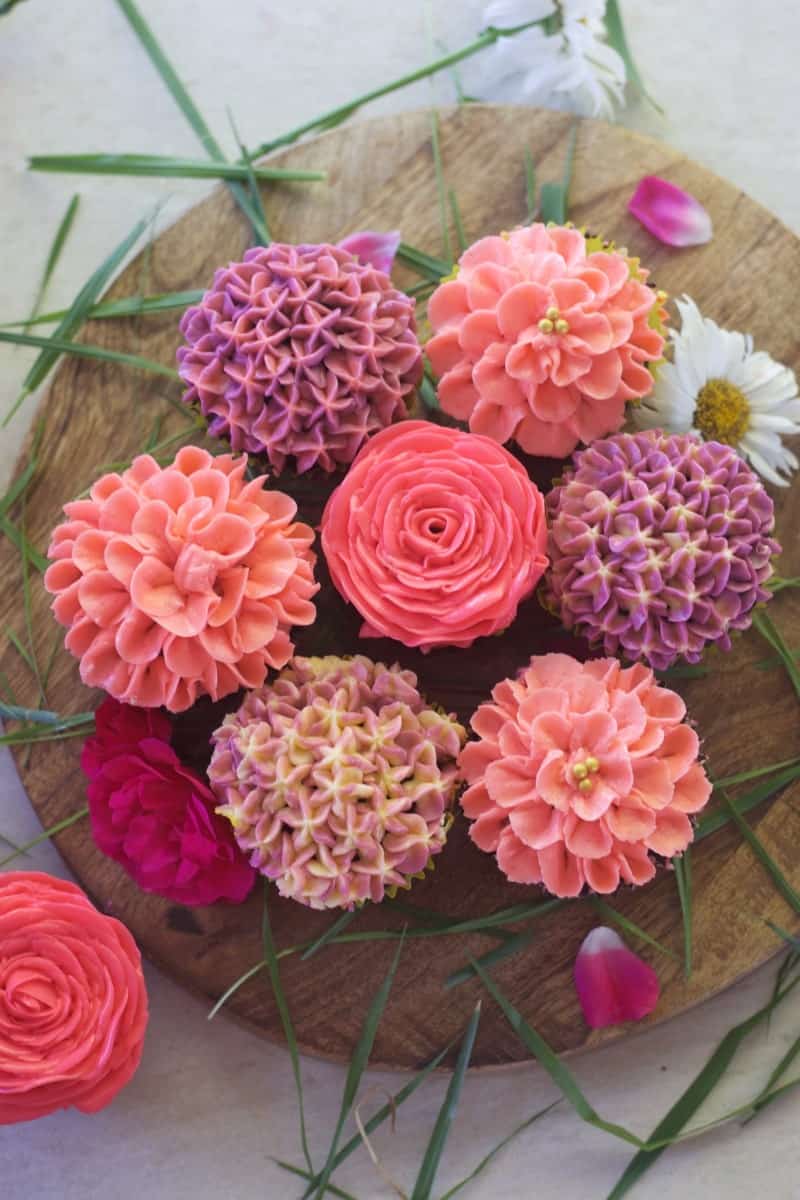 close up view of 7 buttercream flowers placed adjacent to each other forming circle
