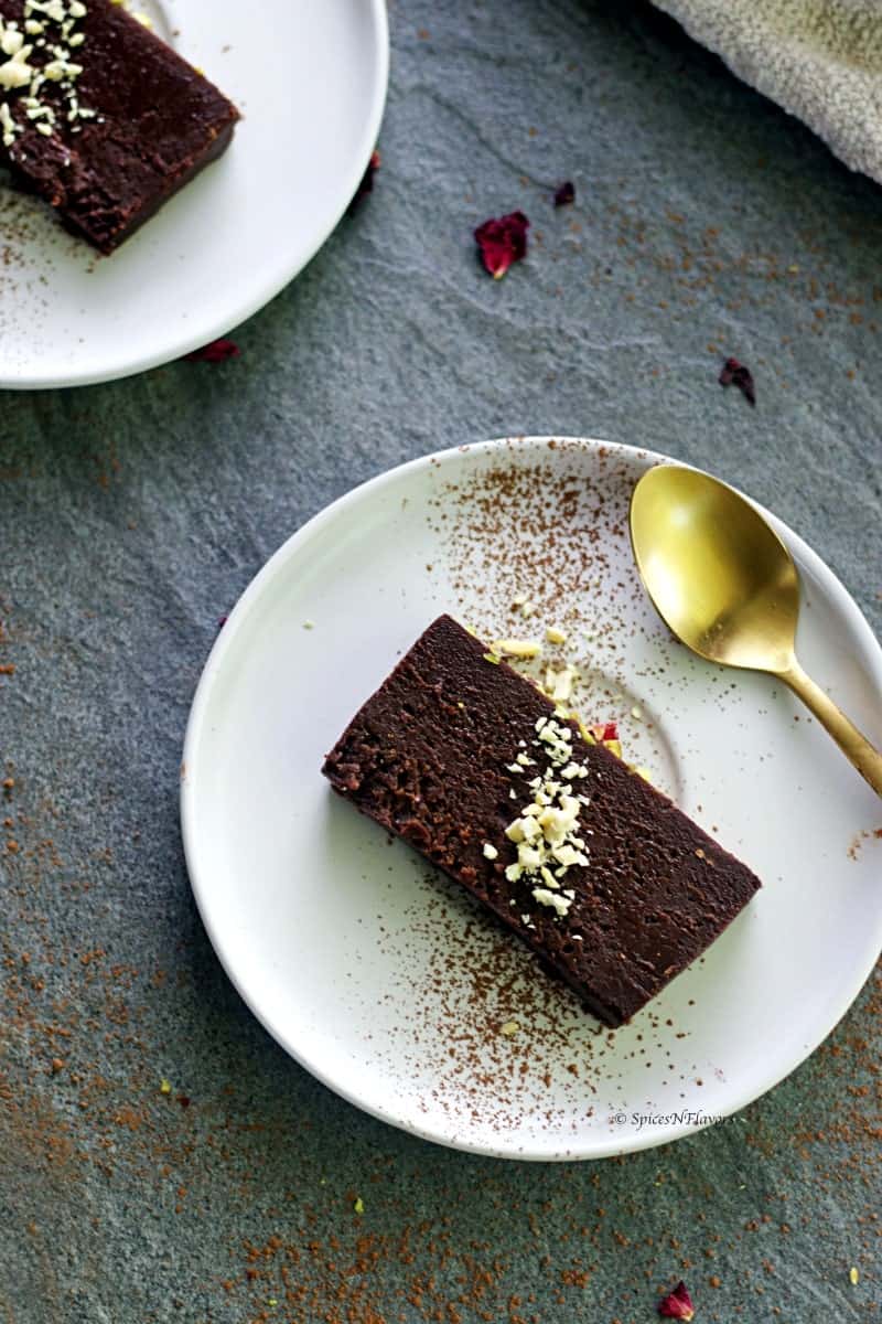 slice of instant pot chocolate terrine served in a white round plate with a golden spoon