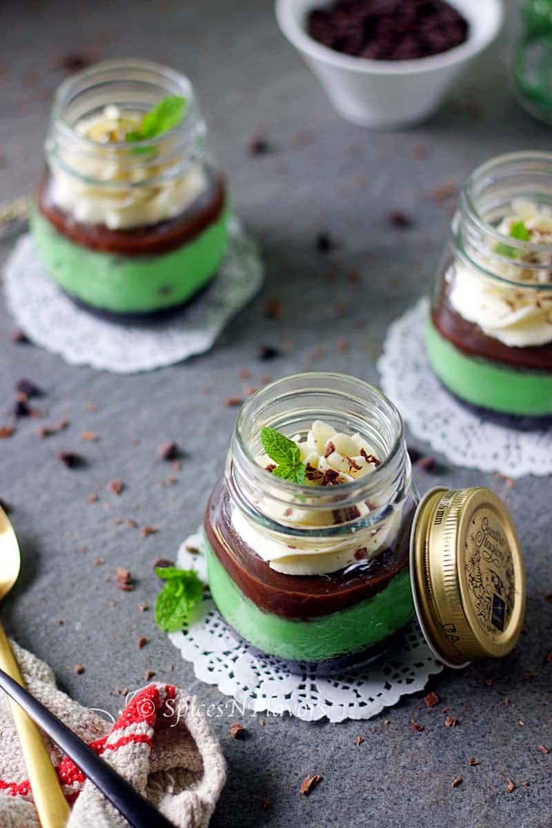 instant pot mint cheesecake jars placed in a triangle shape showing the garnishes on top