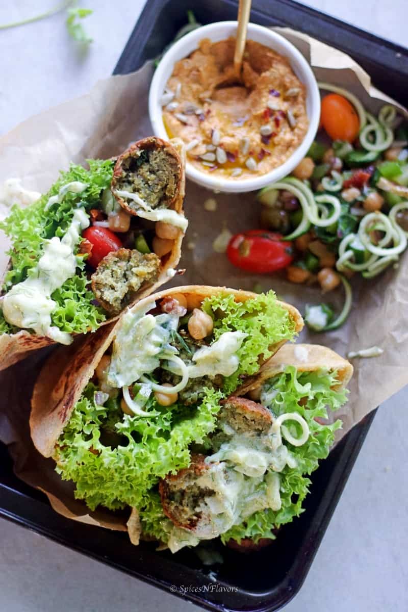 whole wheat pita bread pockets filled with salad, hummus, falafel and sauce