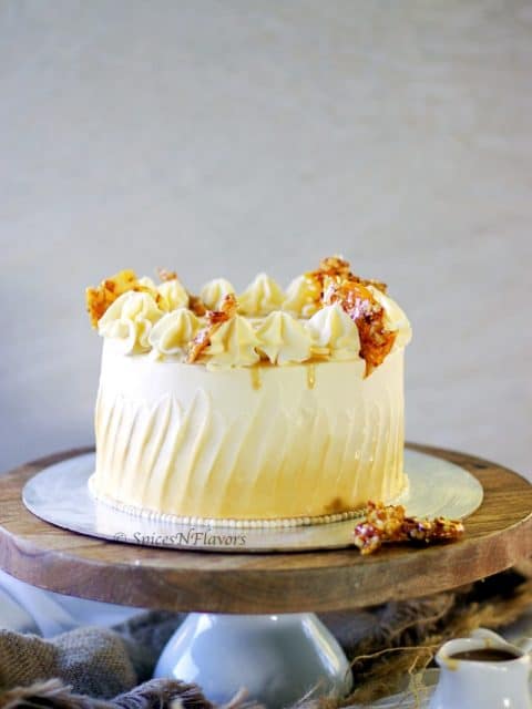 straight image of whole butterscotch cake placed on a cake board and stand