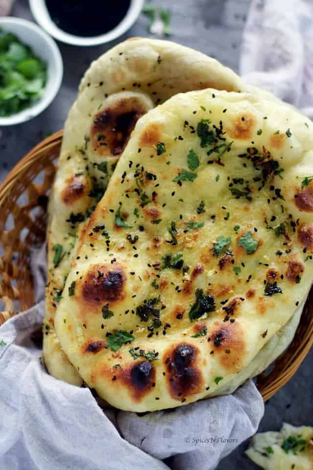 close image of 2 naan breads placed in a basket