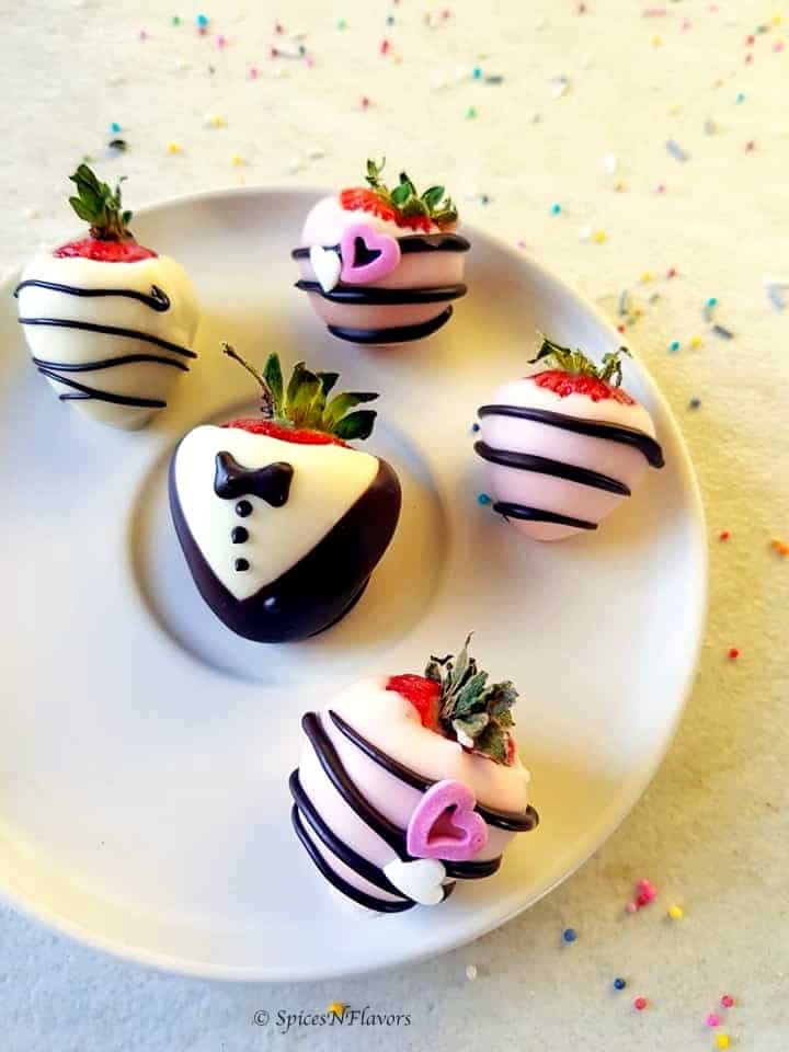 strawberries covered in chocolate placed on a white plate