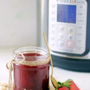 A small mason jar filled with Christmas Jam made in the Instant Pot