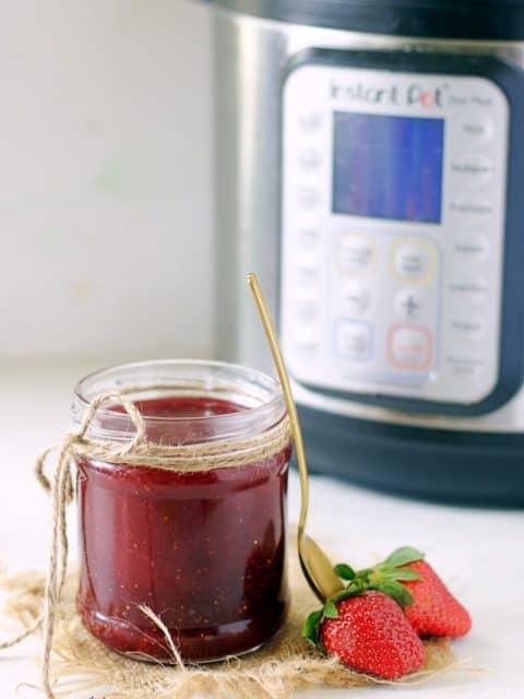 A small mason jar filled with Christmas Jam made in the Instant Pot