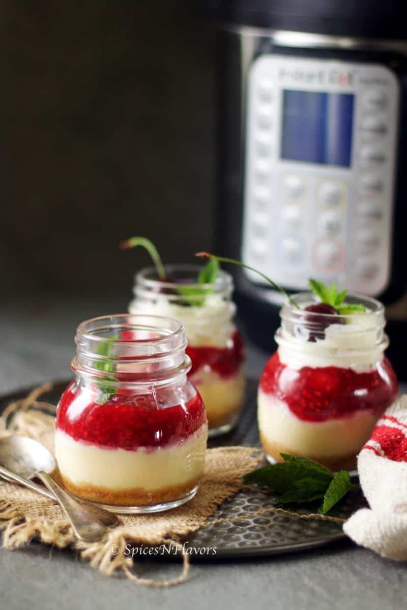 pressure cooked cheesecake made in mason jars is placed in front of the instant pot in which it was made