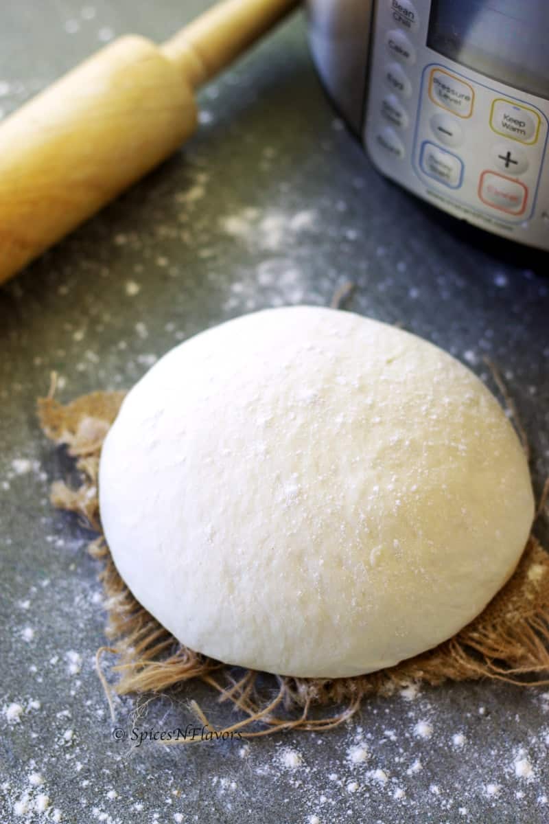 bread dough placed on a towel sprinkled with flour all around