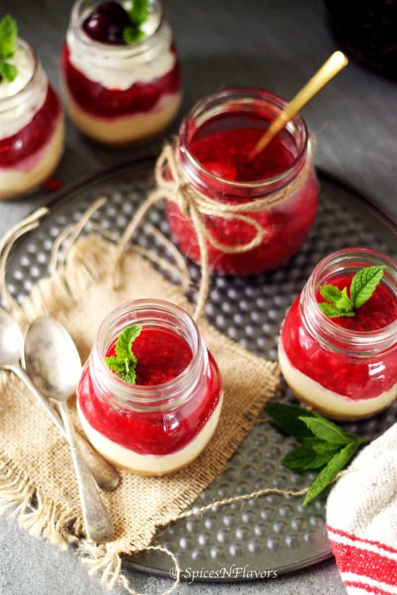 overhead view of the mason jars filled with strawberry sauce and whipped cream decorated with a mint leaf