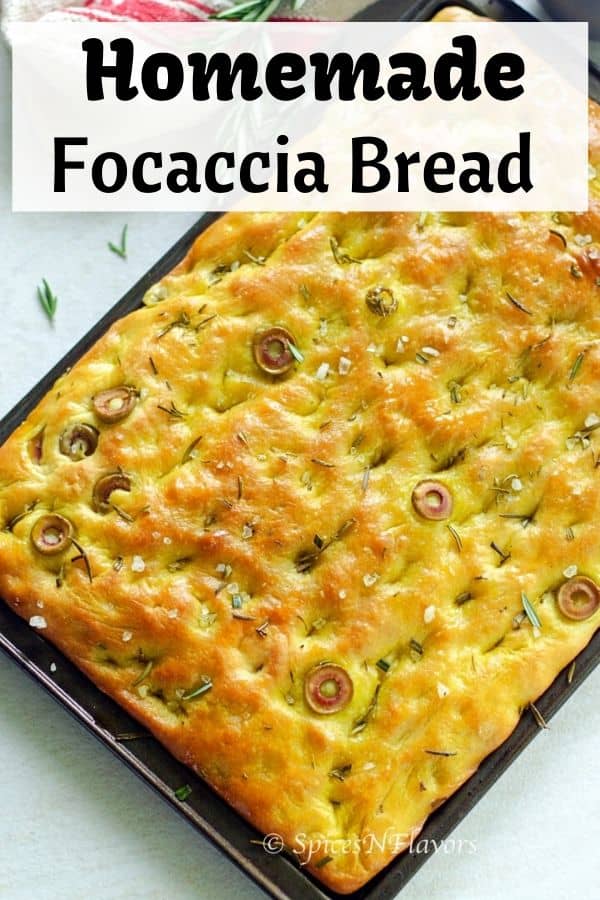 focaccia bread placed in a baking tray with rosemary placed on the side 