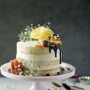 a fully decorated gajar halwa cake placed on a pink cake stand