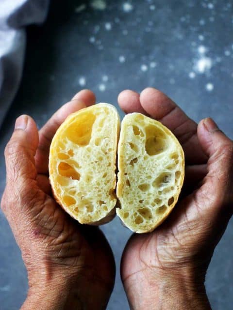 ciabatta bread with open crumbs held in between the palms