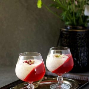 two glasses filled with kheer and jelly placed on a plate