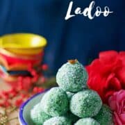 ladoos stacked on each other sitting on a blue rim bowl