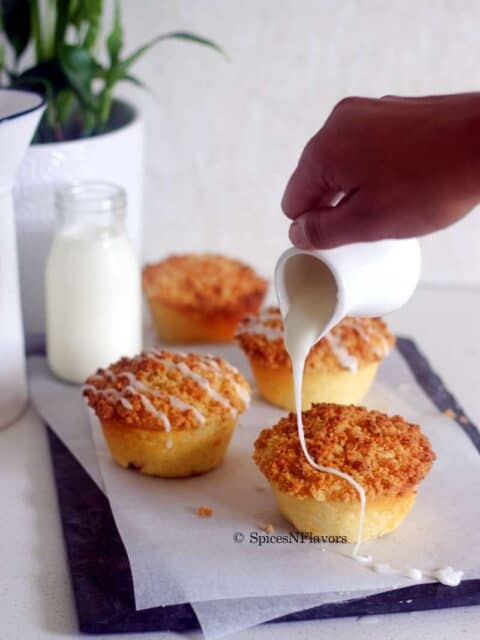 pouring the lemon glaze on top of the lemon crumb muffins
