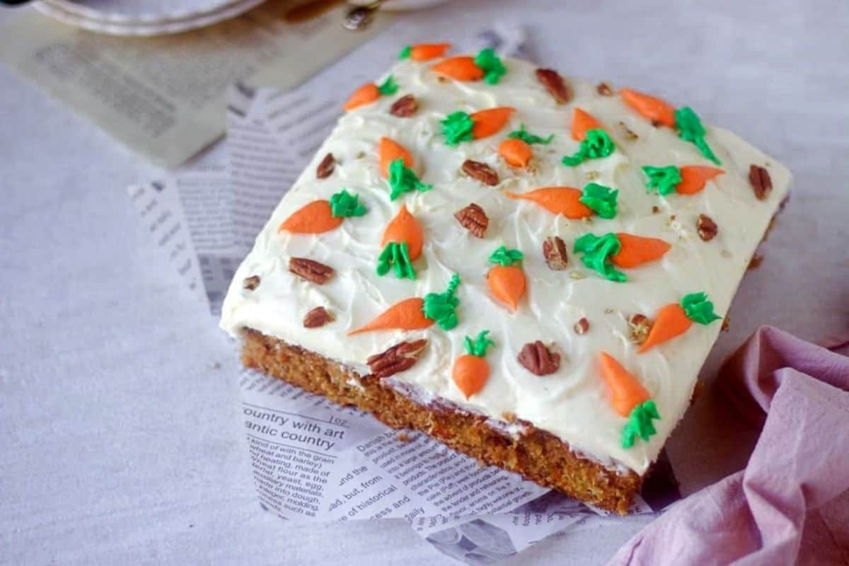 carrot cake frosted with stiff cream cheese frosting placed on a white paper