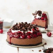 slice of vegan black forest cheesecake lifted to show the texture within