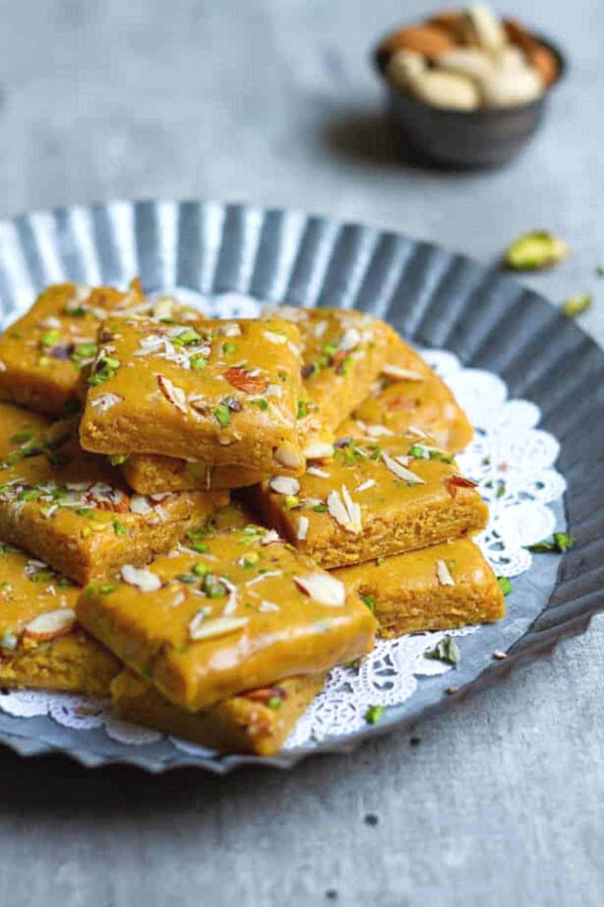 besan burfi squares placed on aluminium tray