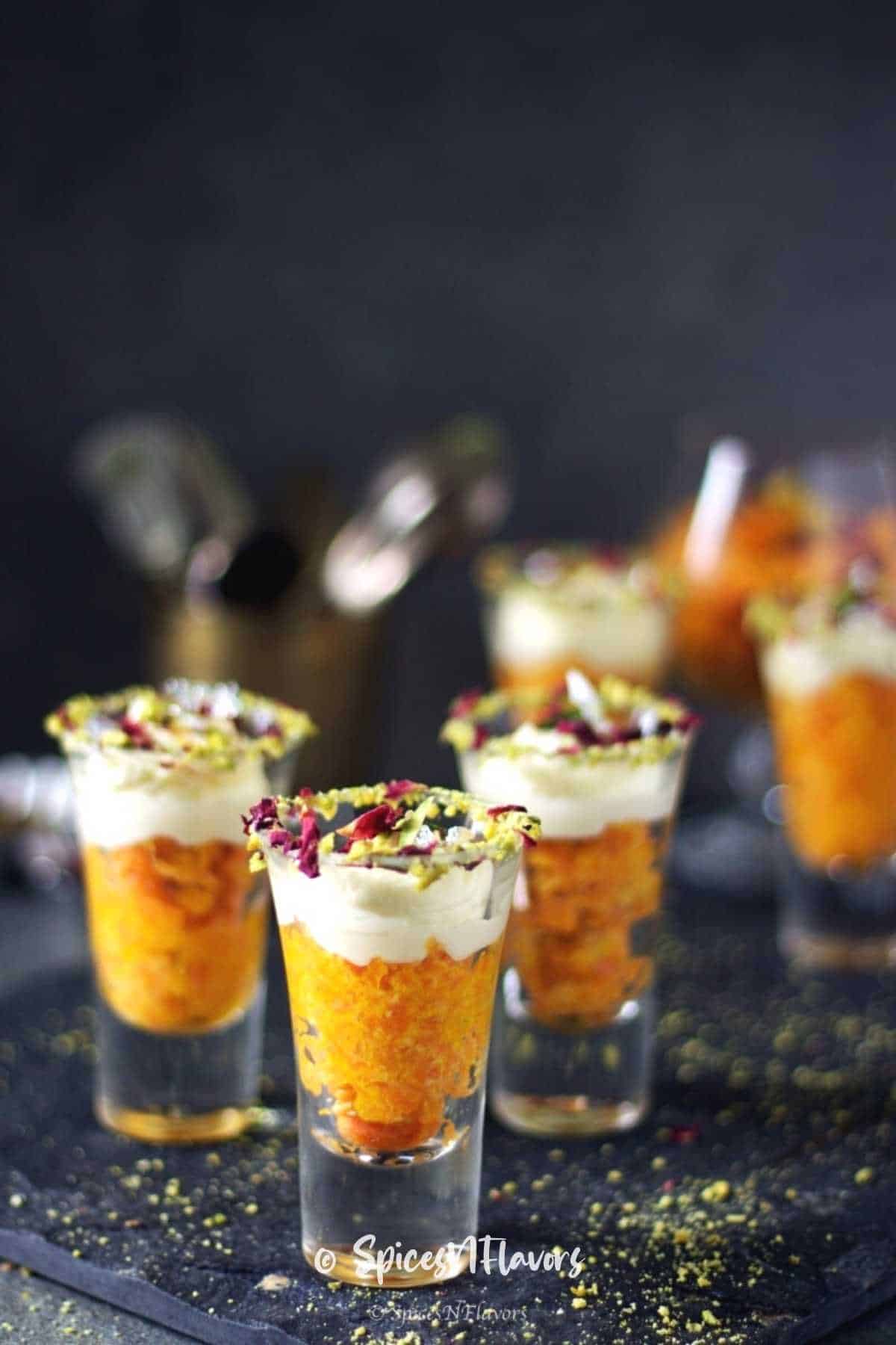 gajar halwa served in shot glasses with whipped cream on top