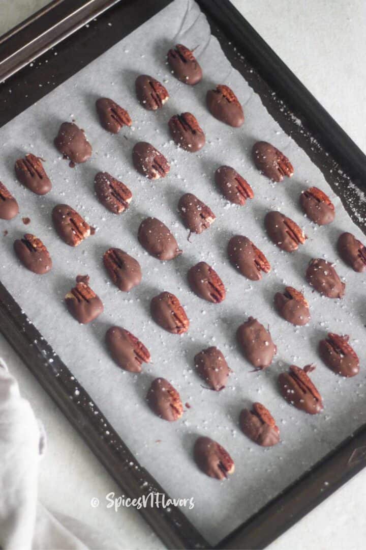 pecans dipped in chocolate placed on baking tray