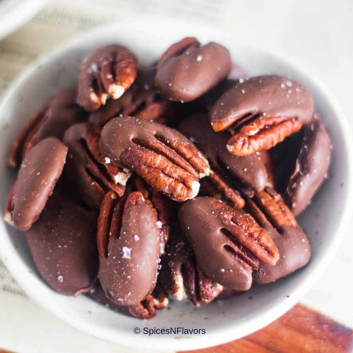close up image of chocolate covered pecans to fit the recipe card image size