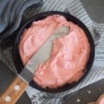 close up image of buttercream frosting placed in a black bowl to fit the recipe card size