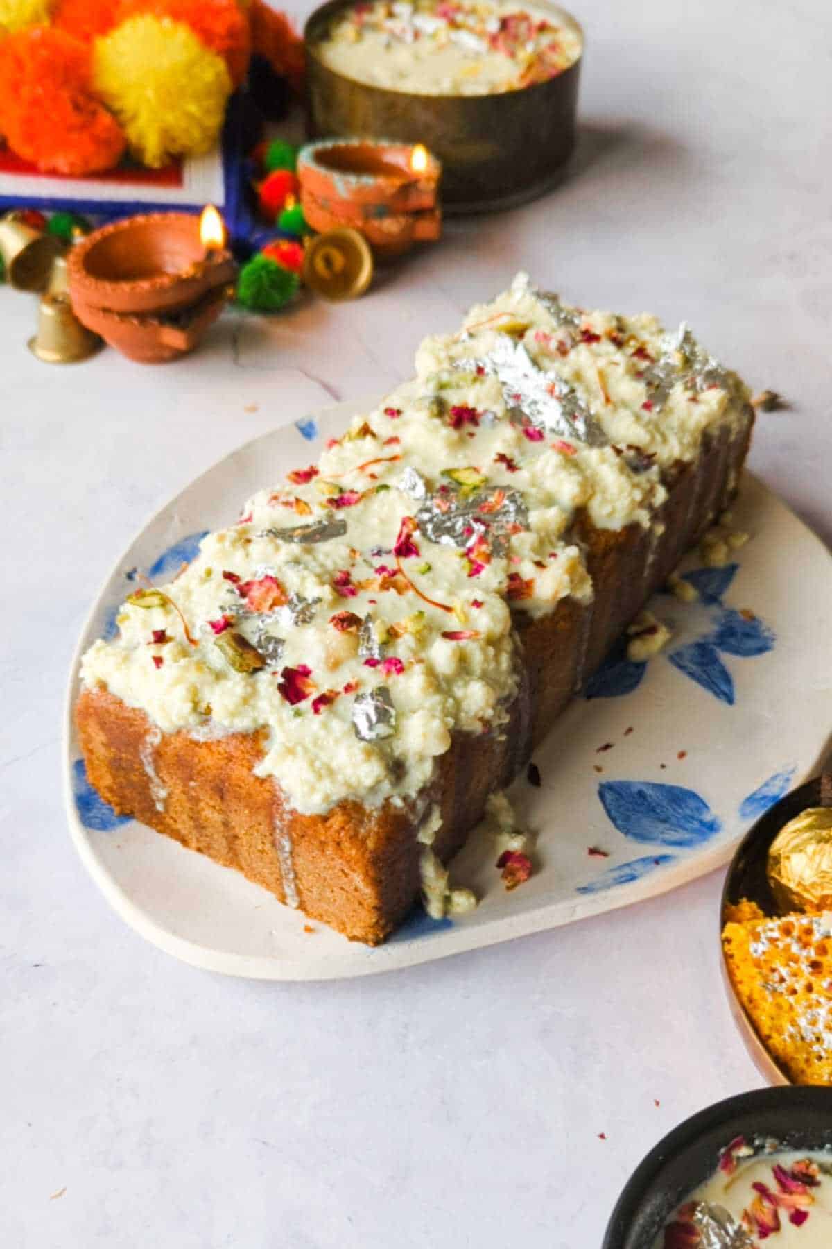 gulab jamun mix loaf cake adorned with instant rabdi placed on a white and blue plate