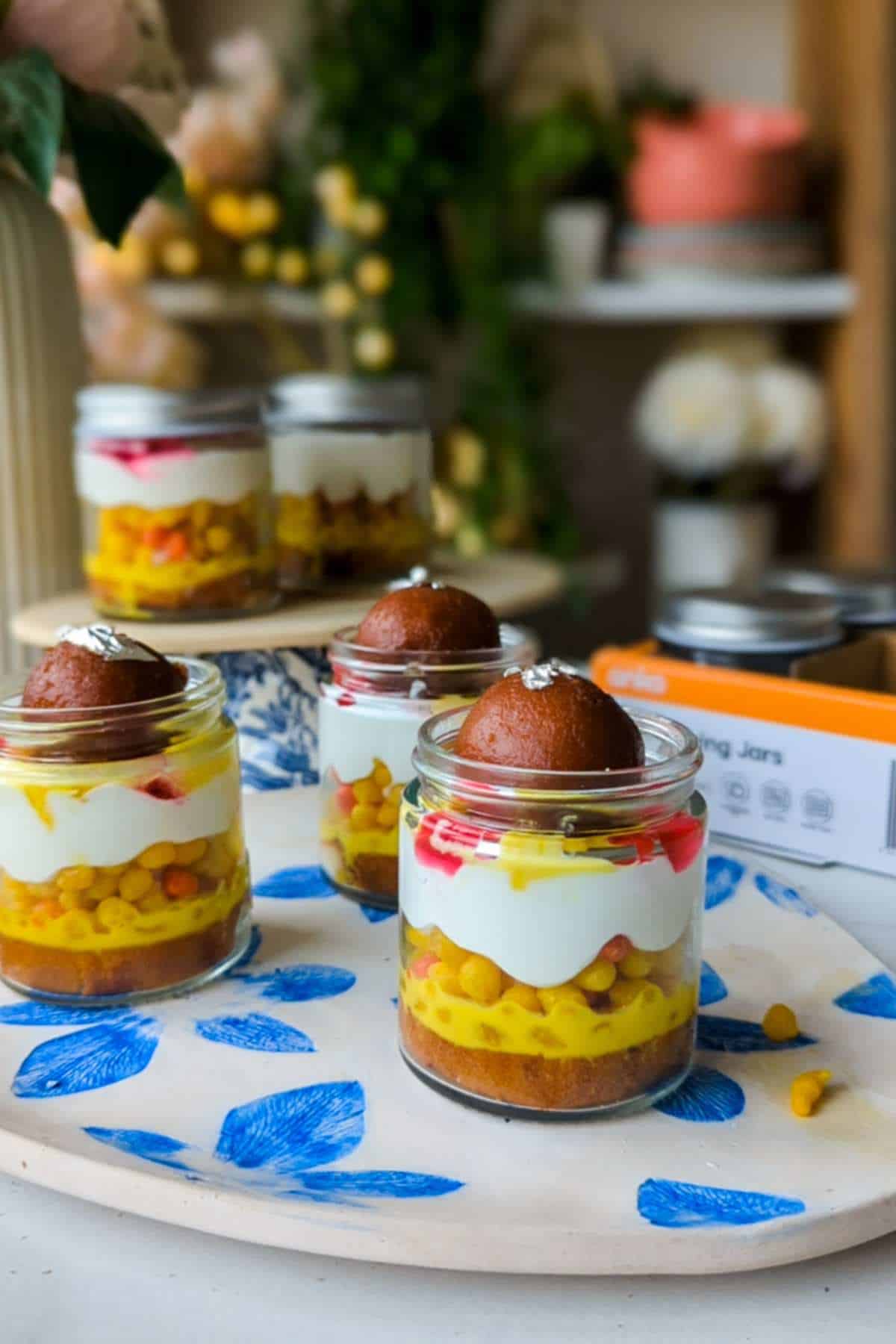a combination of Indian sweets layered in a mason jar with cream cheese mousse