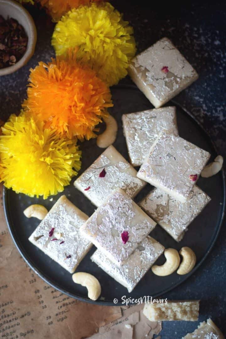 Kaju Barfi squares placed on a black tart pan base