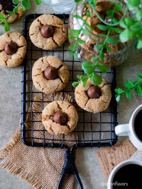 peanut butter blossoms cookies placed on wire rack with coffee on the side