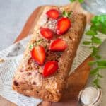 close up image of strawberry bread loaf with fresh strawberries on top to fit the recipe card image