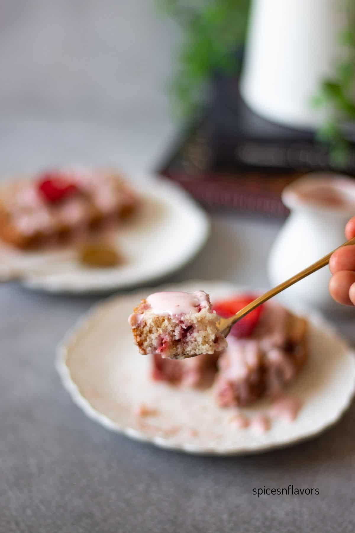 strawberry quick bread on a spoon with the glaze