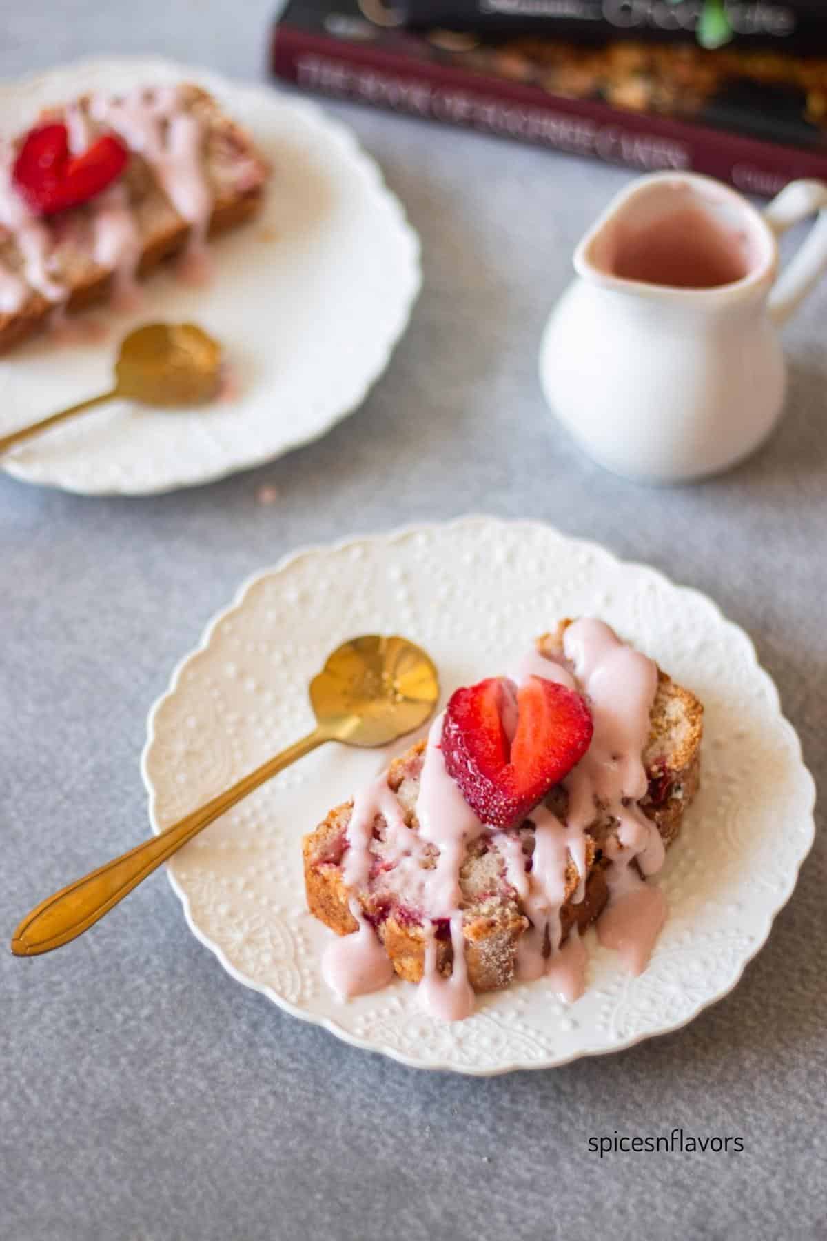 slice of strawberry bread served with glaze and a fresh strawberry on top