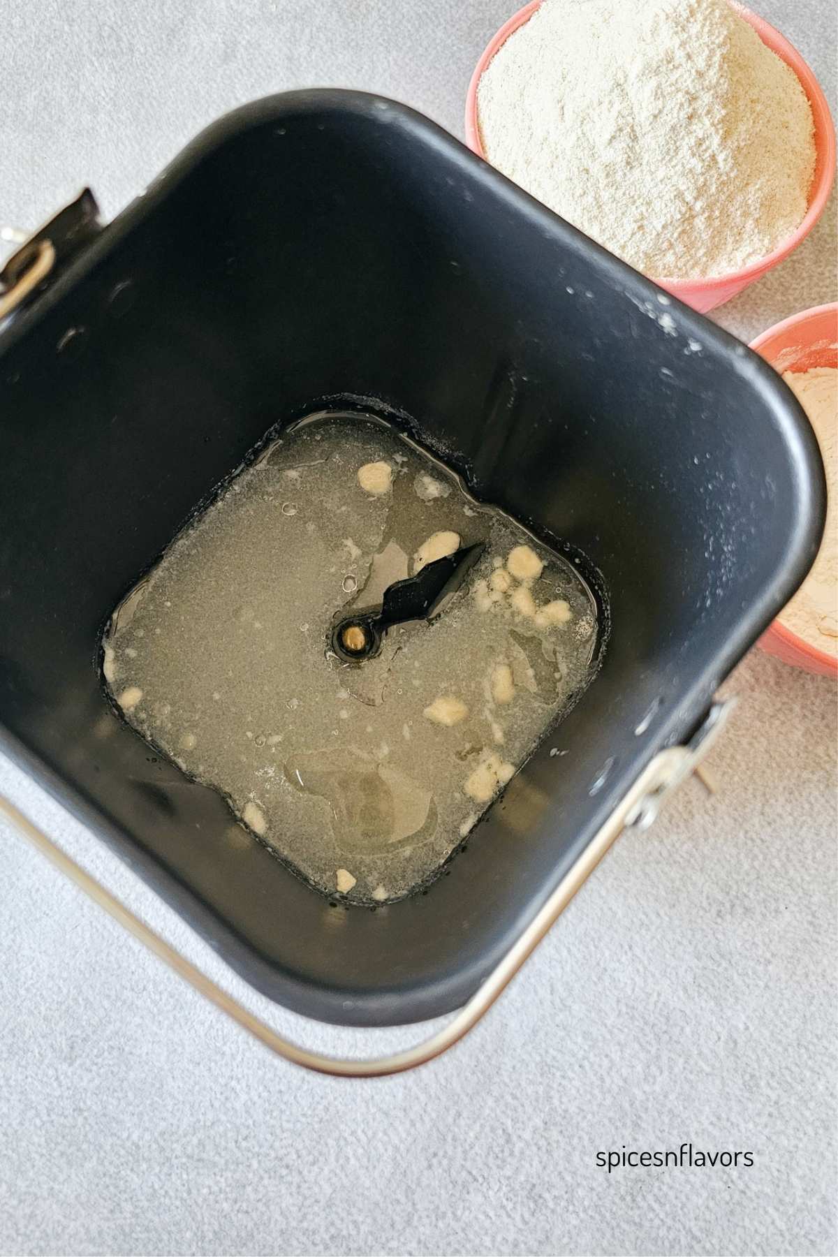 adding wet ingredients to the bread machine pan