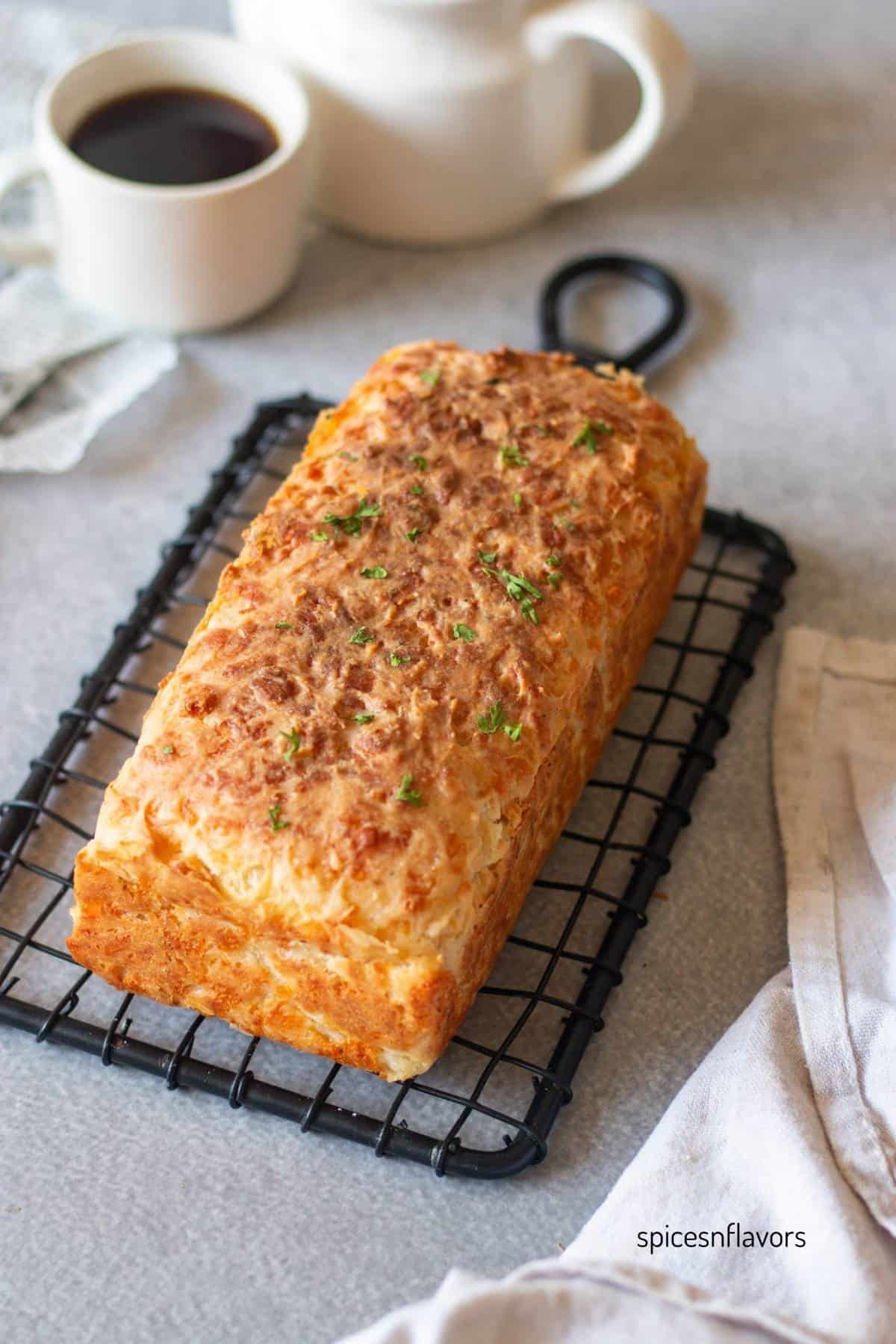 baked cheddar cheese bread placed on a wire rack