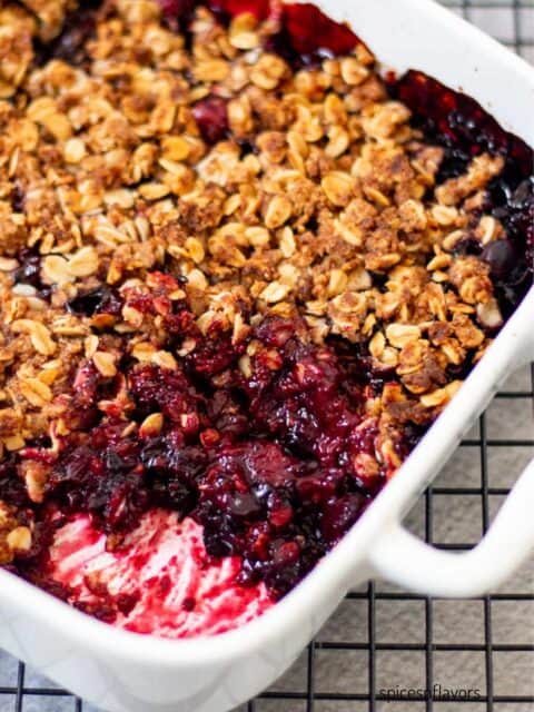 baked mixed berry with crisp on top in a white baking dish