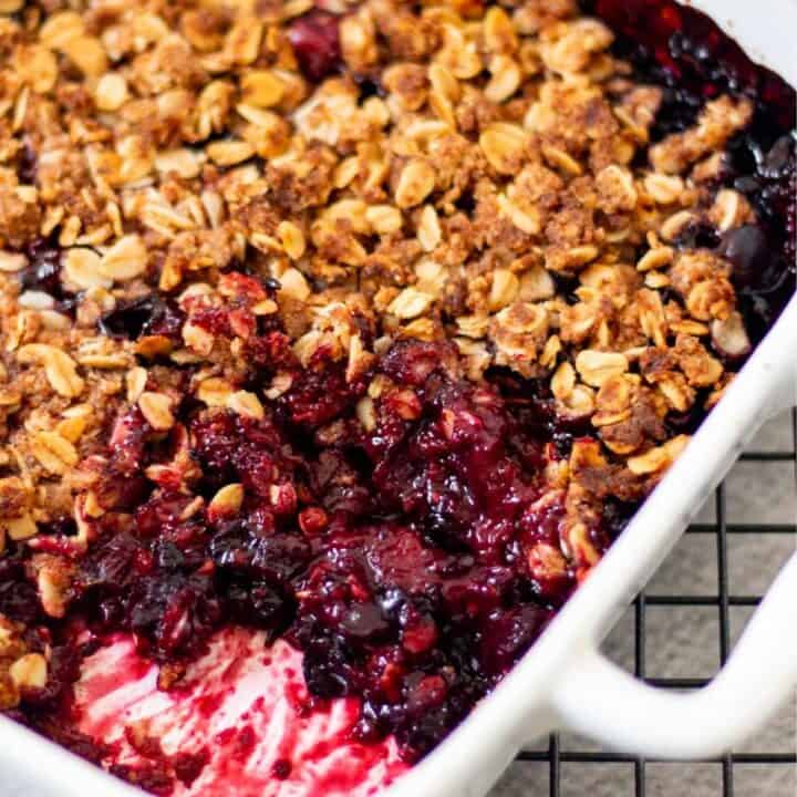 baked mixed berry with crisp on top in a white baking dish