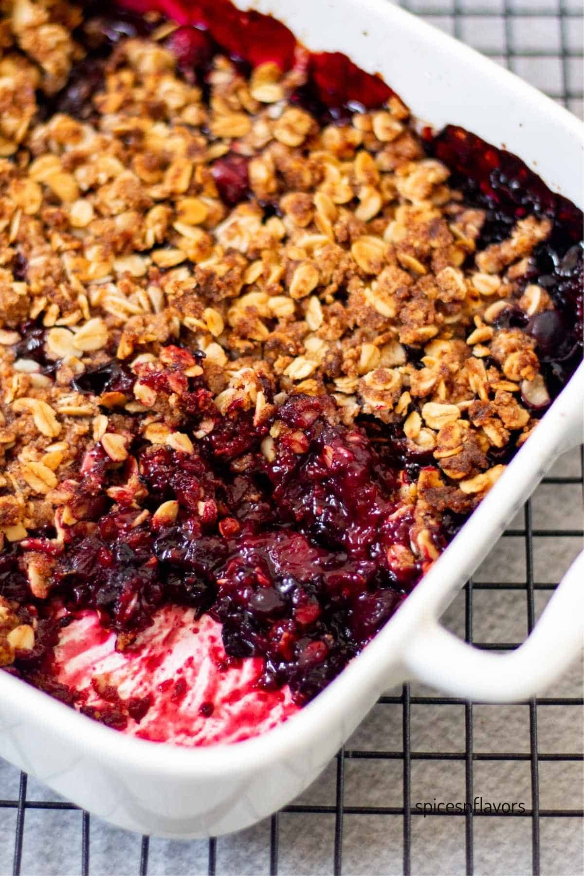 baked mixed berry with crisp on top in a white baking dish