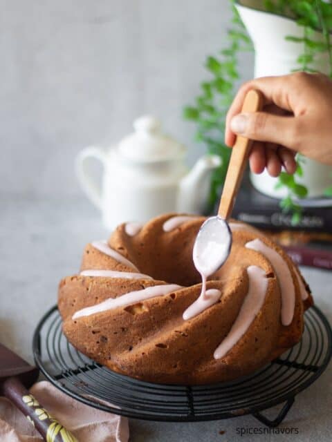 pouring strawberry glaze over strawberry pound cake