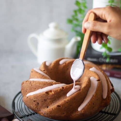 pouring strawberry glaze over strawberry pound cake